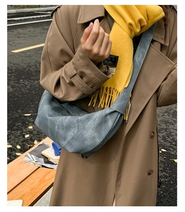 Detailed view of grey-blue crescent hobo bag with vintage matte texture and wide strap