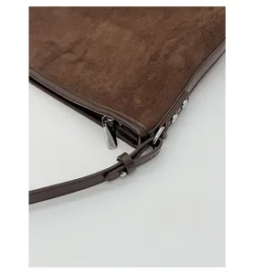 Detail of premium silver hardware and stitching on a dark brown suede tote bag