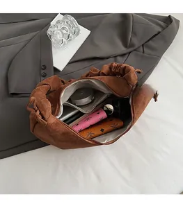 Detailed interior of a brown pleated suede tote bag showing large storage capacity
