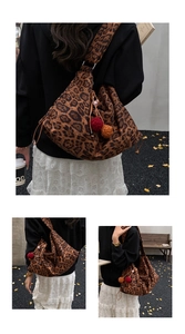 Detail of leopard print tote bag with soft canvas texture and vibrant pompom charm