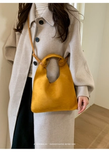 Minimalist ginger yellow hobo shoulder bag shown on model with light grey wool coat