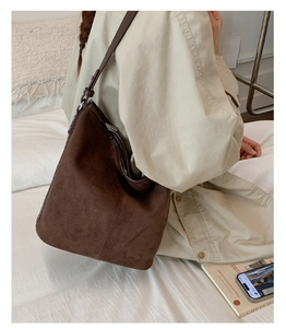 Detail of dark brown suede tote bag with adjustable silver buckle on shoulder strap