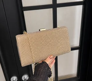 Close-up of golden rhinestone evening clutch with fine metal chain and clasp