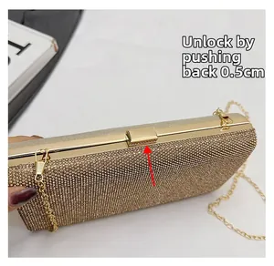 Detail showing the push-back metal buckle lock mechanism on a gold rhinestone evening bag