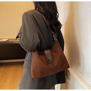 Detail of caramel suede hobo bag with large buckle showing texture and side profile