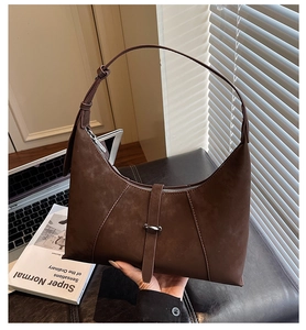 Detail view of the deep coffee suede hobo bag with a decorative metal buckle strap