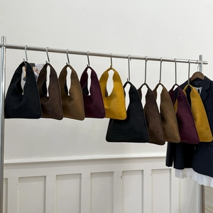 Minimalist suede hobo shoulder bags in five colors displayed on metal hangers
