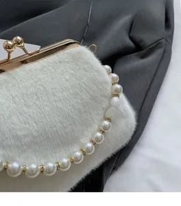 Détail du sac de soirée en peluche blanche avec bandoulière en perles et anneaux strass