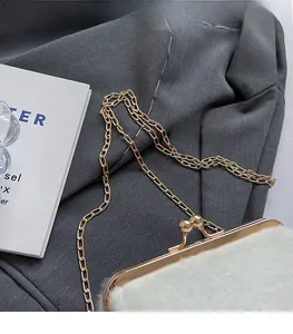 Détail du sac coquille en peluche blanche avec cadre doré, fermoir boule et chaîne