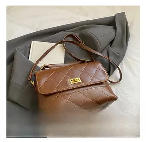 Détail d'un sac à bandoulière marron matelassé avec fermoir rotatif doré et similicuir de qualité