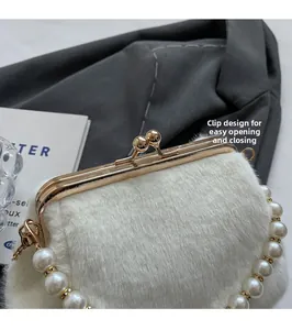 Détail d'un sac en peluche blanc avec fermoir métallique doré et anse en perles de luxe