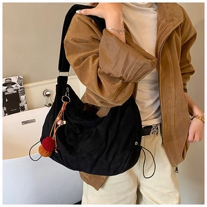 Black suede slouchy hobo shoulder bag retro casual tote purse with cute pom pom charm detail.