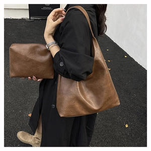 Detail of caramel brown tote bag set with vintage faux leather texture and matching pouch