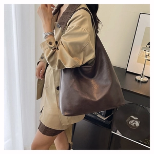 Deep brown oversized hobo shoulder bag styled with a minimalist beige trench coat for autumn