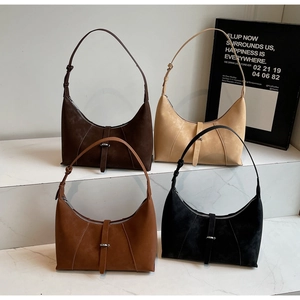Close-up of minimalist suede hobo bags in deep brown, beige, tan and black with metal buckle