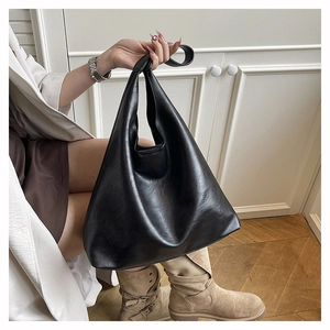 Detail of a black minimalist hobo bag with matte leather finish and spacious interior