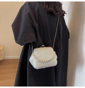 Weiße Plüsch-Handtasche mit goldenem Clipverschluss und Perlenkette an einem Model