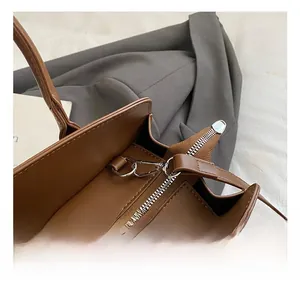 Détail du sac en similicuir marron avec fermeture éclair argentée et coutures fines