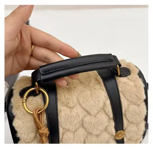 Detail of faux fur bucket bag with heart quilting and contrast leather handles