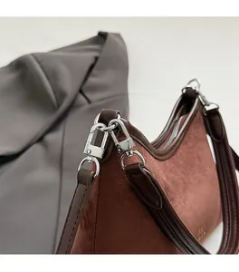 Nahaufnahme der silbernen Hardware und braunem Wildleder auf einer Vintage Eimertasche