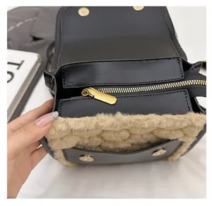 Close-up of smooth gold zipper and beige faux fur trim on a black leather backpack