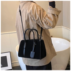 Détail du sac Boston noir mat avec poignées supérieures et bandoulière réglable chic