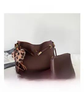 Close-up of large brown tote bag with matching pouch and leopard heart charm
