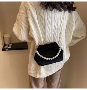 Détail d'un sac bandoulière en peluche noire avec poignée en perles et chaîne métallique