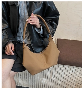 Détail du sac hobo en cuir marron avec texture grainée et couture verticale au milieu