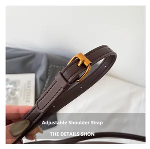 Detail of adjustable dark brown leather strap with gold buckle and neat stitching