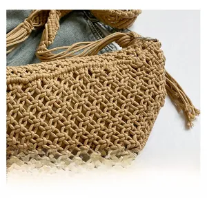 Detailed close-up of woven hollow texture with tassel accents on a khaki straw shoulder bag
