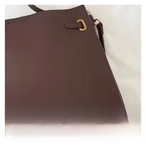 Close-up of high-quality metal hardware buckle and dark brown leather texture on tote bag