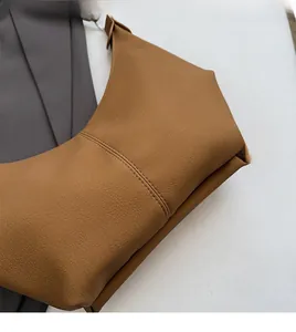 Gros plan du sac à main en cuir grainé caramel montrant la texture et la double couture