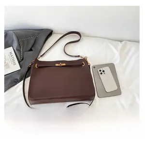 Detail view of brown tote bag with gold twist lock next to tablet for size scale