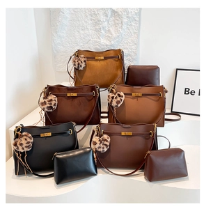 Close-up of vintage suede satchel bags with gold twist locks and leopard print charms