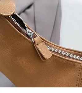 Détail d'un sac à bandoulière en cuir grainé avec fermeture éclair argentée et couture