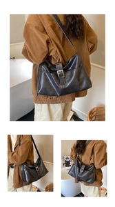 Detail showing the retro black leather tote bag with silver buckle and half-moon shape