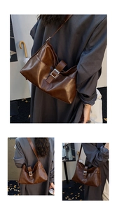 Detail of deep brown retro tote bag with matte leather finish and metal buckle strap
