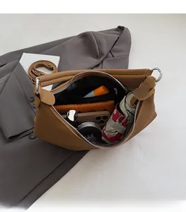 Vue intérieure du sac hobo en cuir marron montrant un grand compartiment de rangement