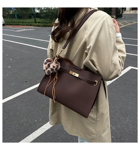 Brown vintage Kelly shoulder bag featuring a gold buckle and leopard heart charm detail