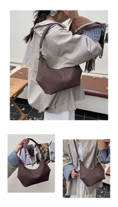 Détail du sac croissant marron foncé montrant le grain lychee et les boucles en métal