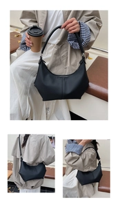 Détail d'un sac demi-lune noir minimaliste avec coutures verticales et garniture en argent