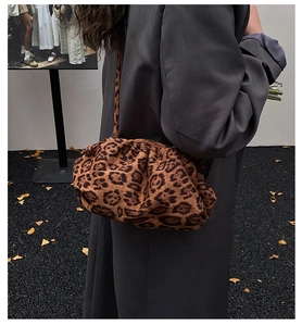 Dettaglio di una borsa a nuvola leopardata alla moda abbinata a un blazer grigio