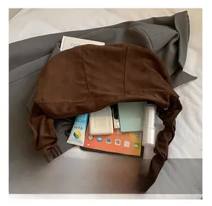 Spacious interior of dark brown suede shoulder bag showing tablets and cosmetics