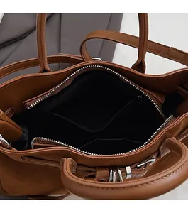 Close-up of caramel suede handbag interior showing large capacity and zipper pockets
