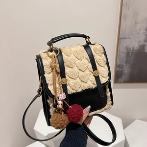 Detail of retro faux leather and heart-textured plush bag with decorative charm