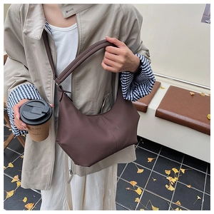 Détail du sac hobo marron foncé avec texture cuir grainé et design à couture verticale