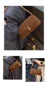 Detail of leopard print shoulder bag with gold metal buckle on brown suede texture