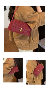 Macro view of red leopard print suede underarm bag with gold metal buckle and texture