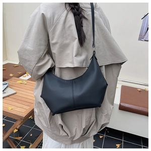 Vue arrière d'un mannequin portant un sac bandoulière croissant en PU noir sur un trench-coat